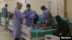 Health workers attend to suspected cholera patients inside a field hospital in Bebnine, Akkar district, northern Lebanon, Oct. 28, 2022.