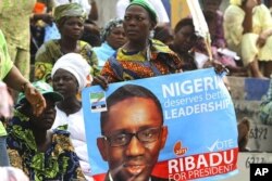A supporter holds a poster campaigning for former anti-graft chief Nuhu Ribadu of the Action Congress of Nigeria