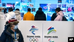 2021 年 2 月 5 日星期五，一名戴著口罩以防止冠狀病毒傳播的記者在北京郊區延慶冬奧會場館的遊客中心觀看展覽。