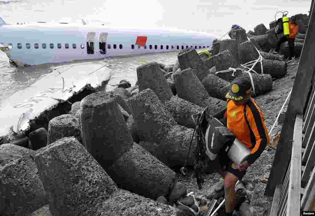 Para anggota tim penyelamat dekat bangkai pesawat Lion Air dekat landasan Bandar Udara Ngurah Rai, Bali, 15 April 2013.