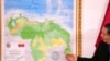 El presidente de la Comisión Especial para la Defensa del Territorio de la Guyana Esequiba, Hermann Escarra, de pie junto al nuevo mapa de Venezuela que incluye el Esequibo, durante una ceremonia de develación en Caracas, el 8 de diciembre de 2023. 