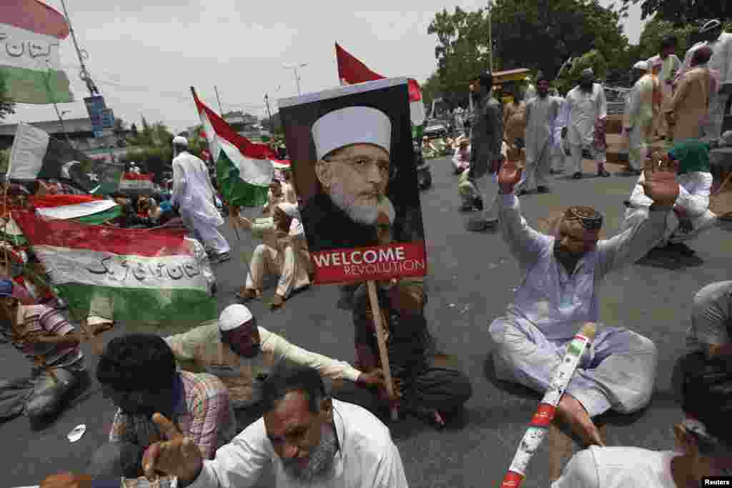 Supporters of cleric Tahir-ul-Qadri chant slogans as they participate in a sit-in protest in Karachi after his plane was diverted from Islamabad to Lahore, June 23, 2014.