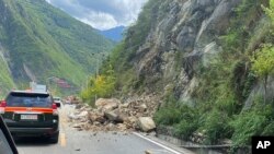 中国西南部四川省甘孜州泸定县当地时间星期一（2022年9月5日）下午发生6.8级地震。新华社发布的照片显示地震造成山体滑坡，巨石滚落，车辆通行受阻。-美联社/新华社照。