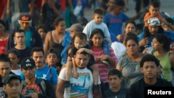 Ratusan migran asal Amerika Tengah berjalan bersama melewati perbatasan Guatemala – Meksiko, dekat Ciudad Hidalgo, Meksiko, 5 Juni 2019.

