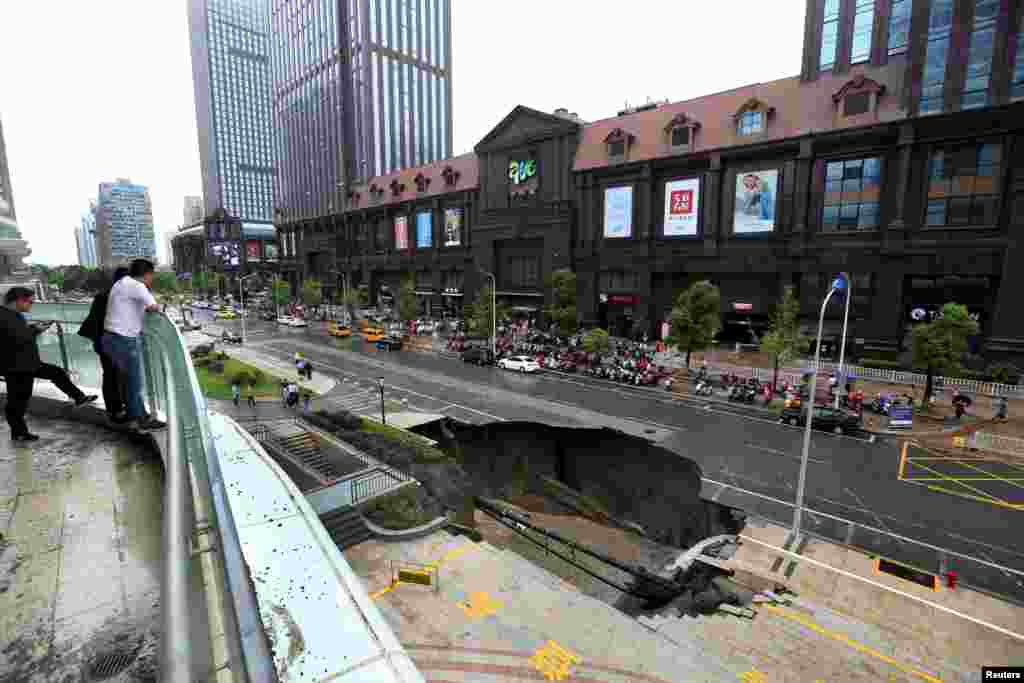 Warga mengamati bagian dari jalan raya yang ambles di kota Nantong, Jiangsu, China.