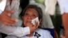 Former Social Affairs Minister Ieng Thirith, center, Ieng Sary's wife, cries during the cremation ceremony of his husband at his home of a former stronghold of Malai, 420 kilometers (260 miles) from Cambodian-Thai border, northwestern of Phnom Penh, Cambodia, Thursday, March 21, 2013. 