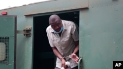Le journaliste d'investigation zimbabwéen Hopewell Chin'ono sort d'une fourgonnette de prison devant le tribunal de première instance à Harare, le 6 novembre 2020.