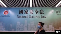 行人走過香港街頭港版國安法的宣傳牌。 （2020年7月28日）