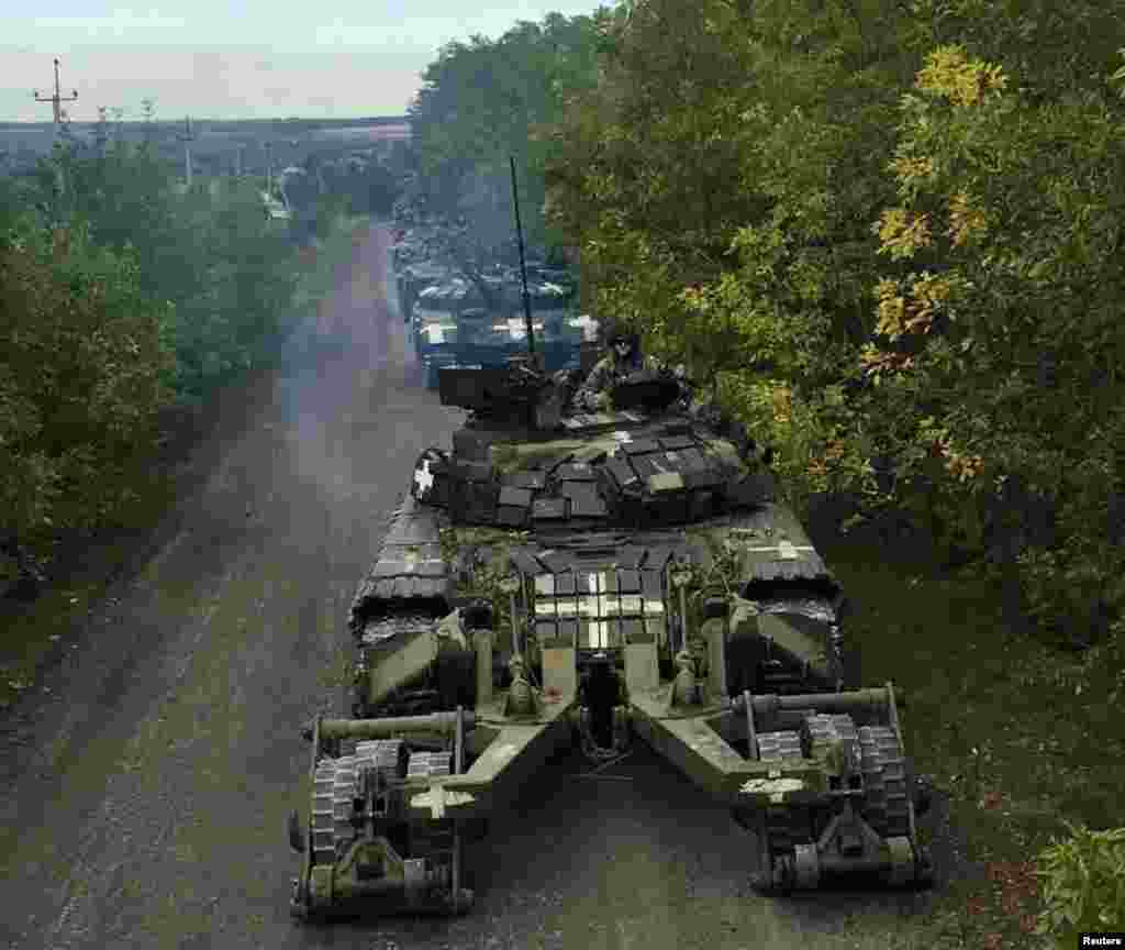 Ukrainian service members ride on tanks during a counteroffensive operation in the Kharkiv region of Ukraine, in this handout picture released by the Armed Forces of Ukraine.