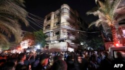 Palestinians gather in front of a building as firefighters extinguish a blaze that broke out in one of the apartments in the Jabaliya refugee camp in the northern Gaza strip, Nov. 17, 2022.
