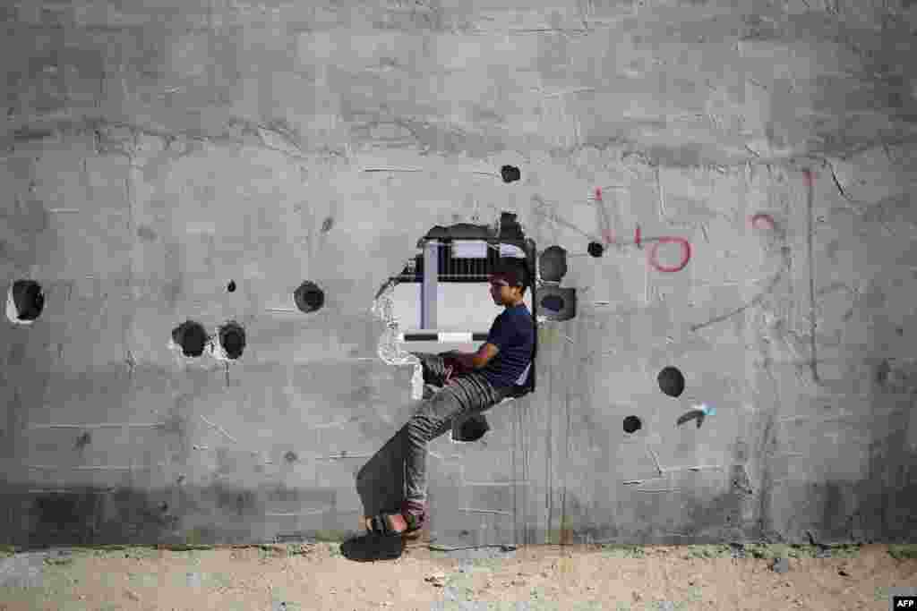 A Palestinian boy sits and watches aid trucks as they arrive for processing at the Kerem Shalom (Karm Abu Salem) border crossing.