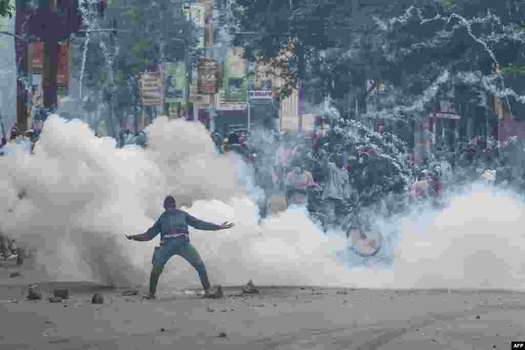 A teargas canister detonates as a protester gestures at Kenyan anti-riot police officers during anti-government protests in Nairobi. Police were out in force in the center of Kenya's capital after calls for more demonstrations against the embattled government of President William Ruto.