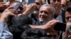 Kandidat reformis dalam pemilihan presiden Iran Masoud Pezeshkian disambut oleh para pendukungnya saat ia tiba untuk memberikan suara di tempat pemungutan suara di Shahr-e-Qods dekat Teheran, Iran, 5 Juli 2024. (Foto: AP)