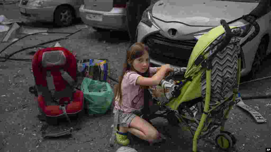 A 10-year-old girl looks after her 3-year-old sister at the site of Okhmatdyt children's hospital hit by Russian missiles, in Kyiv, July 8, 2024.