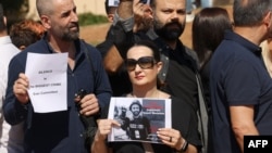 Mwanamke akishikilia picha ya mwandishi Issam Abdallah, aliyeuawa Oktoba 13 katika kijiji Alma al-Shaab kusini mwa Lebanon, wakati wa maandamano ya kupinga mauaji hayo huko Beirut, Oktoba. 15, 2023.