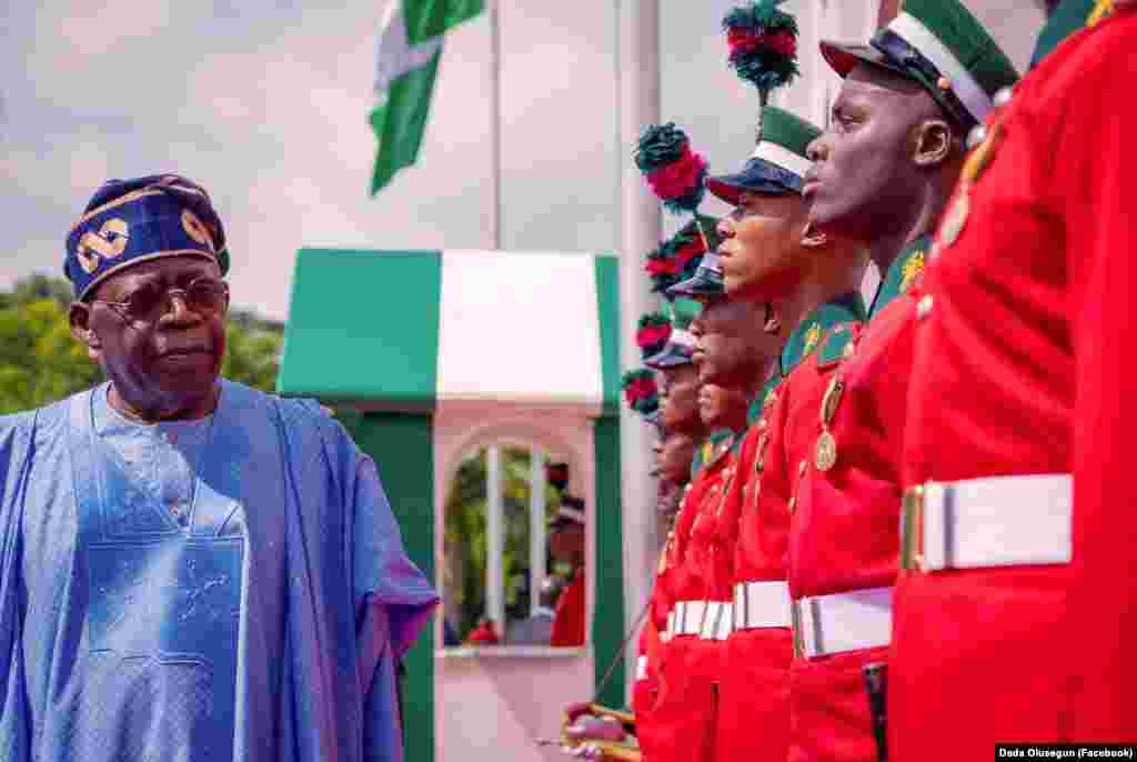 Shugaban Najeriya Bola Ahmed Tinubu yana duba jami'an tsaro a faretin bikin ranar dimokuradiyya a fadarsa