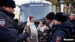 Women demanding the return of their husbands who joined the Russian armed forces involved in a military campaign in Ukraine, stand surrounded by police during a gathering in central Moscow, Feb. 3, 2024.