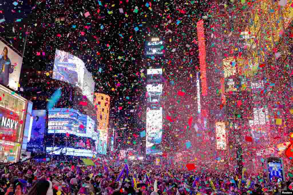 People watch confetti flying around after the clock strikes midnight during New Year celebrations at Times Square, in New York City, New York, Jan. 1, 2024.