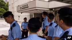Police officers stand guard outside the High Court ahead of the hearing for an injunction to ban the 2019 protest song "Glory to Hong Kong" in Hong Kong, Friday, July 21, 2023.