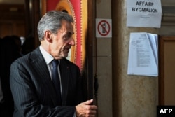 Mantan presiden Prancis Nicolas Sarkozy keluar setelah putusan dalam sidang banding dalam kasus Bygmalion, di gedung pengadilan, di Paris, pada 14 Februari 2024. (Bertrand GUAY / AFP)