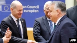 Kanselir Jerman Olaf Scholz (kiri) berjabat tangan dengan Perdana Menteri Hungaria Viktor Orban saat mereka berbicara sebelum dimulainya pertemuan Dewan Eropa di markas besar Eropa di Brussels, 1 Februari 2024. (Ludovic MARIN / AFP)