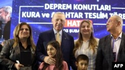 Turkish President Recep Tayyip Erdogan presents a woman a key to a post-quake house during the Drawing and Key Handover Ceremony of Post-Quake Houses, in Hatay, southern Turkey, Feb. 3. 2024. (Photo by Handout/Turkish Presidential Press Service / AFP)