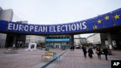 FILE - Orang-orang berjalan di bawah spanduk pemilu Eropa di luar Parlemen Eropa di Brussels, 24 Januari 2024. (AP/Virginia Mayo)
