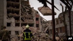 Firefighters work on a building that was partially destroyed in a Russian bombardment in Chernihiv, Ukraine, April 17, 2024. 