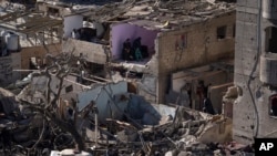 Warga Palestina sedang melihat dampak serangan Israel terhadap bangunan tempat tinggal dan masjid di Rafah, Jalur Gaza, 22 Februari 2024. (Foto: AP)