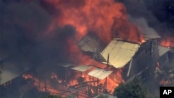 FILE - This image made from video shows home engulfed in flames outside Perth, Australia, Dec. 21, 2023.
