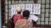 Des électeurs vérifient leurs noms sur la liste électorale au lycée Boganda de Bangui, le 30 juillet 2023.