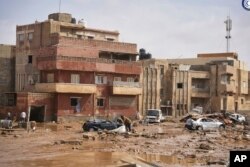 In this photo provided by the Libyan government, cars and rubble sit in a street in Derna, Libya, on Monday, Sept. 11, 2023, after it was flooded by heavy rains. (Libyan government via AP)