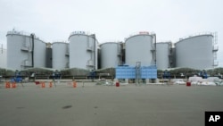 2023年7月14日，在日本二葉町的福島第一核電站，一條黑色管道沿著裝有處理過的放射性廢水的水箱延伸。