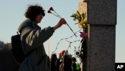 俄國民眾在聖彼得堡政治壓迫受害者紀念碑獻花，紀念納瓦爾尼。（2024年2月18日）