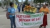La guatemalteca Lucía Quié (derecha) posa junto a sus hijas portando un cartel que reza "nuestra economía depende de los inmigrantes" durante la marcha organizada en este sábado 1 de julio en Homestead, Florida, contra la ley SB 1718.