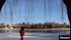 Mwanaume akipita kwenye maji ya bahari yalioganda kutokana na baridi mjini Beijing, China. Desemba 22, 2023.