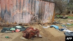 FILE - A picture taken June 16, 2023, shows covered bodies strewn near houses in the West Darfur capital, El Geneina, amid fighting in war-torn Sudan.