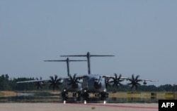 Dua pesawat militer Airbus A400M dari Bundeswehr Angkatan Bersenjata Jerman mendekat pada latihan militer "Air Defender 2023" di pangkalan udara militer di Wunstorf, Jerman utara, 12 Juni 2023. (Ronny Hartmann / AFP)