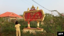 စစ်အာဏာသိမ်းဆန့်ကျင်ရေးလှုပ်ရှားမှုတခုအတွင်း မြင်းခြံမြို့အဝင် ဆိုင်းဘုတ်ကို ဆေးပက်ဖြန်းနေသူတဦး (ဧပြီ ၂၅၊ ၂၀၂၁)