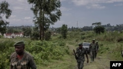 Waasi wa kundi la M23 wakilinda doria wakati wa mkutano kati ya maafisa wa Kikosi cha Afrika Mashariki (EACRF) na waasi wa M23 katika kambi ya Rumangabo huko DRC Januari 6, 2023. Picha na Guerchom Ndebo/AFP