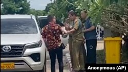 在這張由一位不願透露姓名的消息人士拍攝的影片中，兩名活動人士中的一位（左）與中國維權律師盧思位（右）同行，與拘留盧思位的警察發生爭執，2023 年7月28 日。（匿名消息來源向美聯社提供照片）