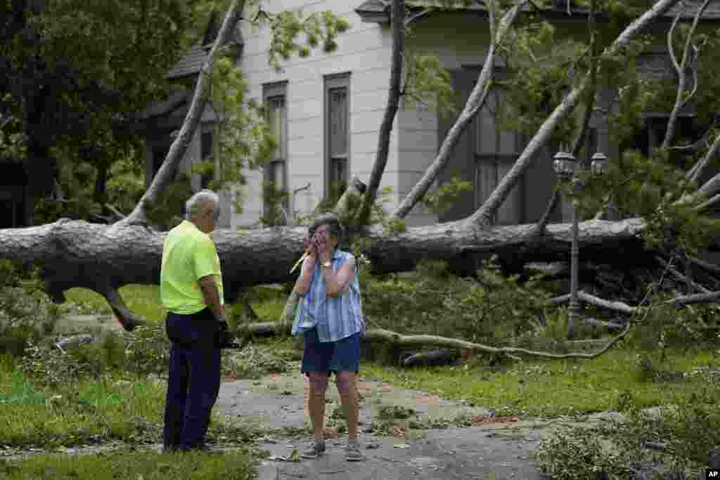 Jackie Jecmenek, right, talks with city worker Bobby Head as she stands in front of her neighbor's home after Hurricane Beryl passed, July 8, 2024, in Bay City, Texas.