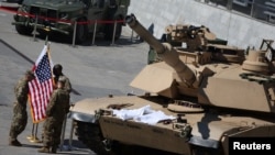 Tentara AS tampak berada di dekat tank M1 Abrams yang diparkir di luar aula pada ajang Ekshibisi Industri Pertahanan Internasional di Kielce, Polandia, pada 5 September 2022. (Foto: Reuters/Kacper Pempel)