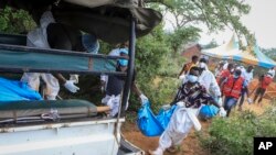 Polisi na wakazi wapakia ndani ya lori miili ya waumini wa dhehebu moja la Kenya katika kijiji cha Shakahola, karibu na mji wa pwani wa Malindi, Aprili 23, 2023.