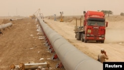 Sejumlah pekerja tampak memasang jalur pipa gas alam di tengah badai pasir yang melanda wilayah perbatasan antara Irak dan di Iran di Basra, yang terletak di sebelah tenggara Baghdad, pada 12 April 2016. (Foto: Reuters/Essam Al-Sudani)