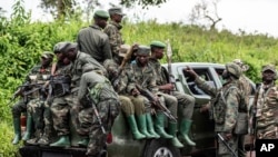 FILE - M23 rebels load a pickup truck in Kibumba, in the eastern of Democratic Republic of Congo, Dec. 23, 2022. 