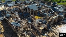 Bangunan-bangunan yang runtuh akibat banjir di Meizhou, provinsi Guangdong, China selatan, 21 Juni 2024. Hujan deras di provinsi Guangdong minggu ini memicu banjir dan tanah longsor, dengan serangkaian cuaca ekstrem yang berdampak secara nasional. (AFP)