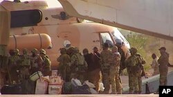 FILE - This undated photograph provided by the French military shows Russian mercenaries boarding a helicopter in northern Mali. 