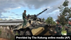 Anggota kelompok angkatan bersenjata etnis, yang dikenal sebagai Aliansi Tiga Persaudaraan, memeriksa kendaraan lapis baja tentara yang diduga disita kelompok tersebut dari pos terdepan tentara Myanmar di sebuah bukit di kotapraja Hsenwi di negara bagian Shan, 24 November 2023.