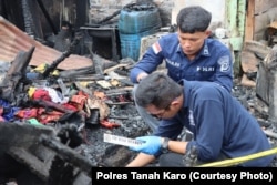 Polisi tengah berada di rumah jurnalis yang terbakar di Kabanjahe, Kabupaten Karo, Sumatera Utara, 27 Juni 2024. (Foto: Polres Tanah Karo)
